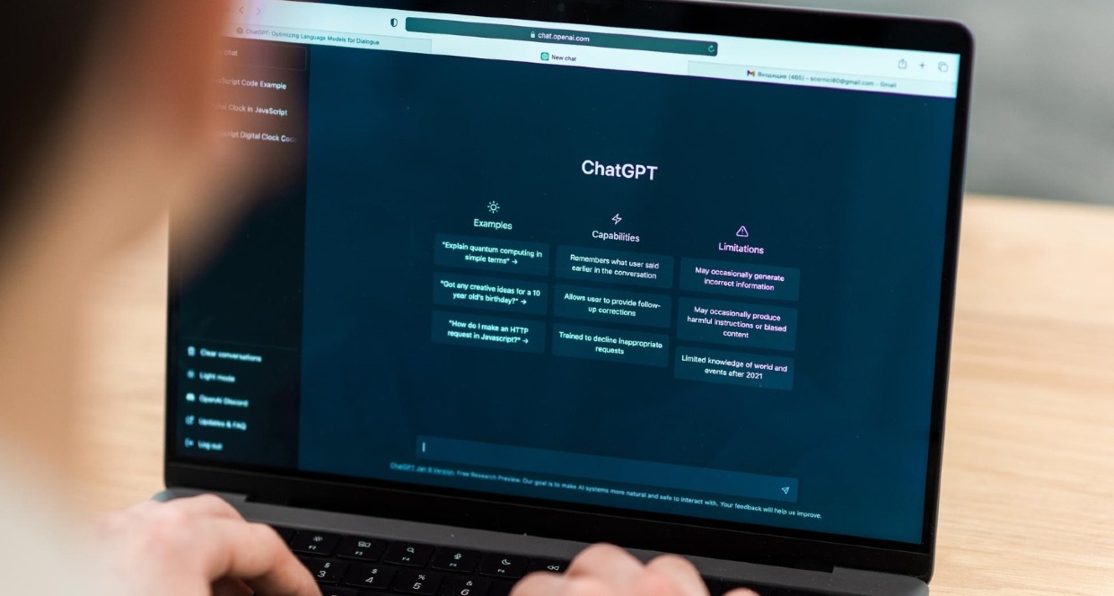 OpenAI revela cómo se utiliza ChatGPT Un hombre usando el ordenador con ChatGPT en la pantalla