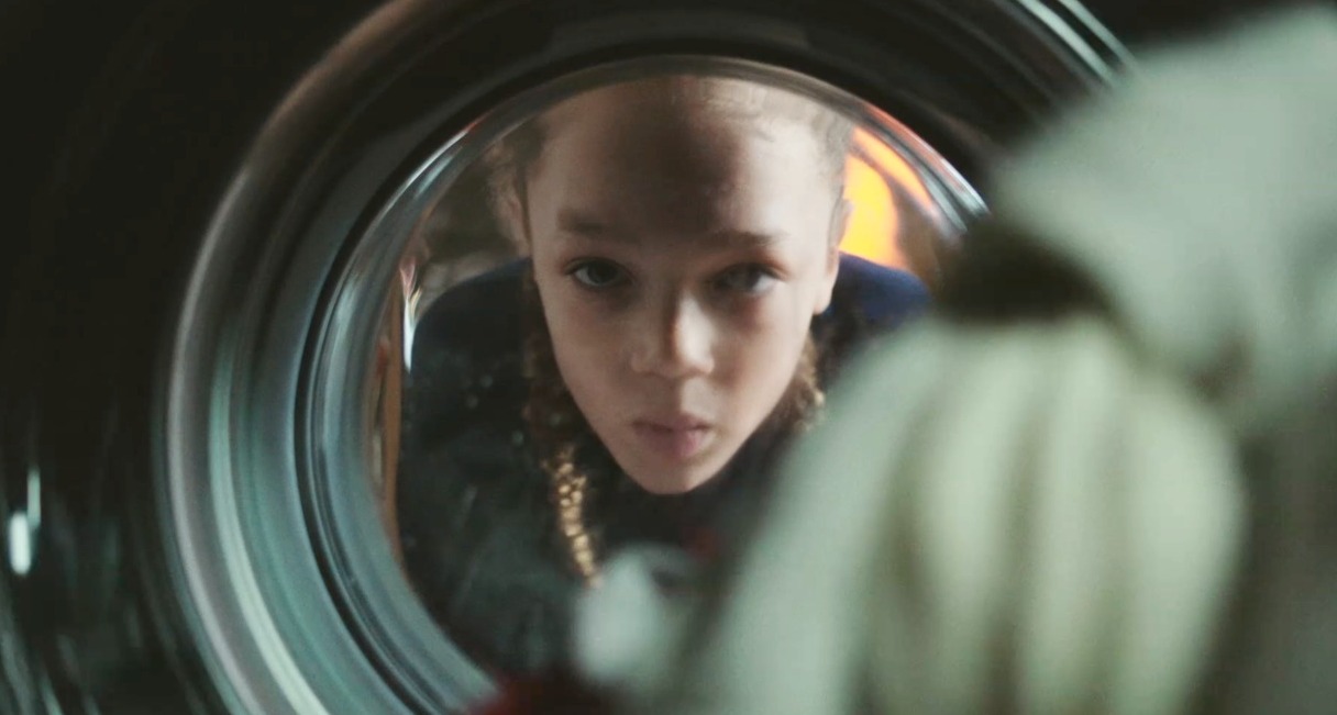 niño mirando a través de la lavadora