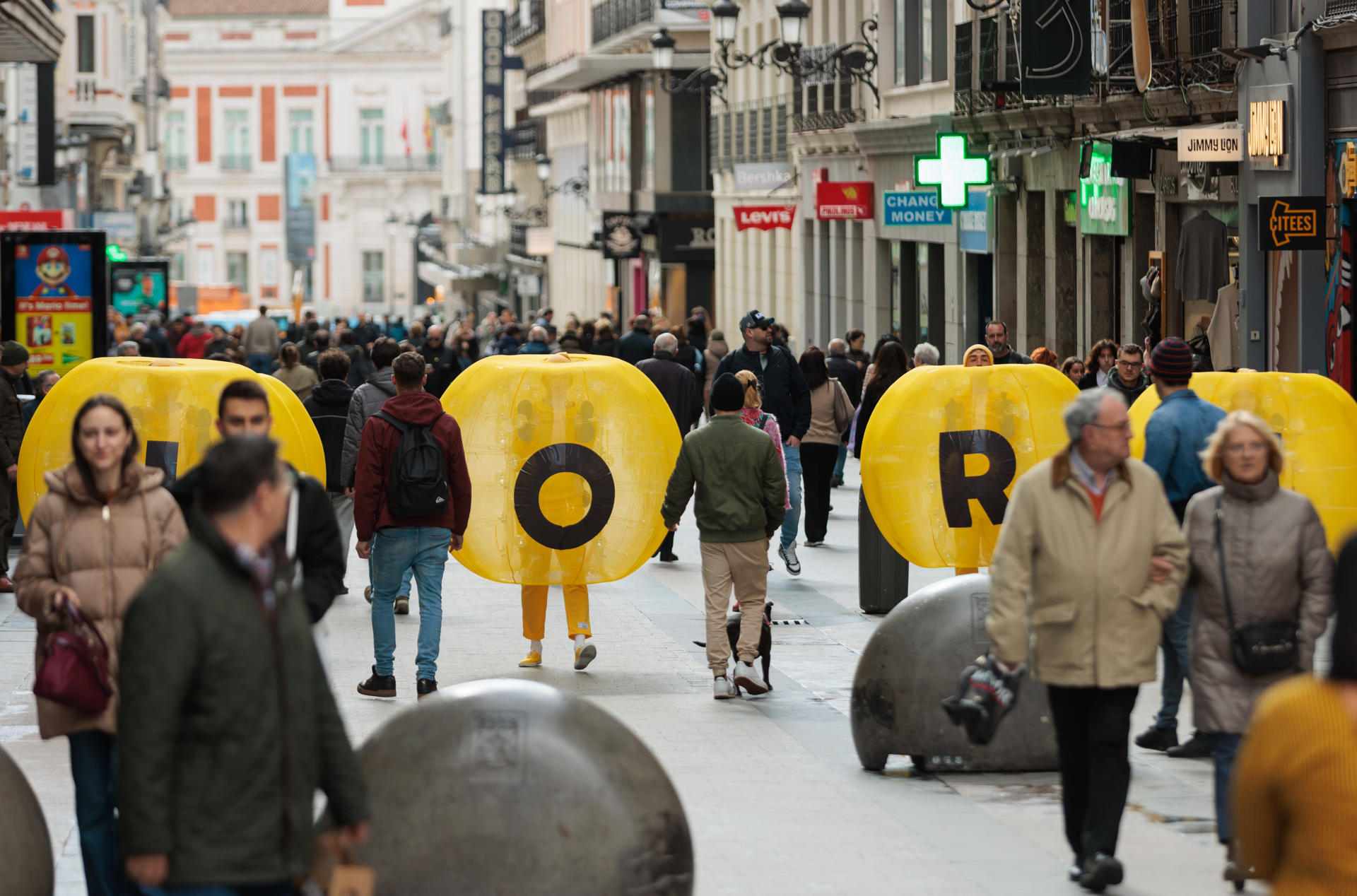 Las esferas amarillas caminando enrtre los peatones por el centro de Madrid