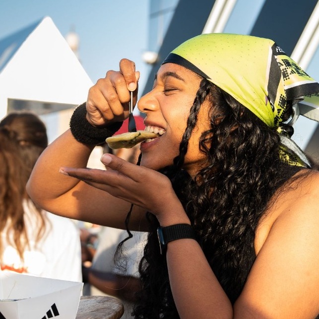 Una chica se come los raviolis de Adidas con forma de zapatilla y las tres franjas negras