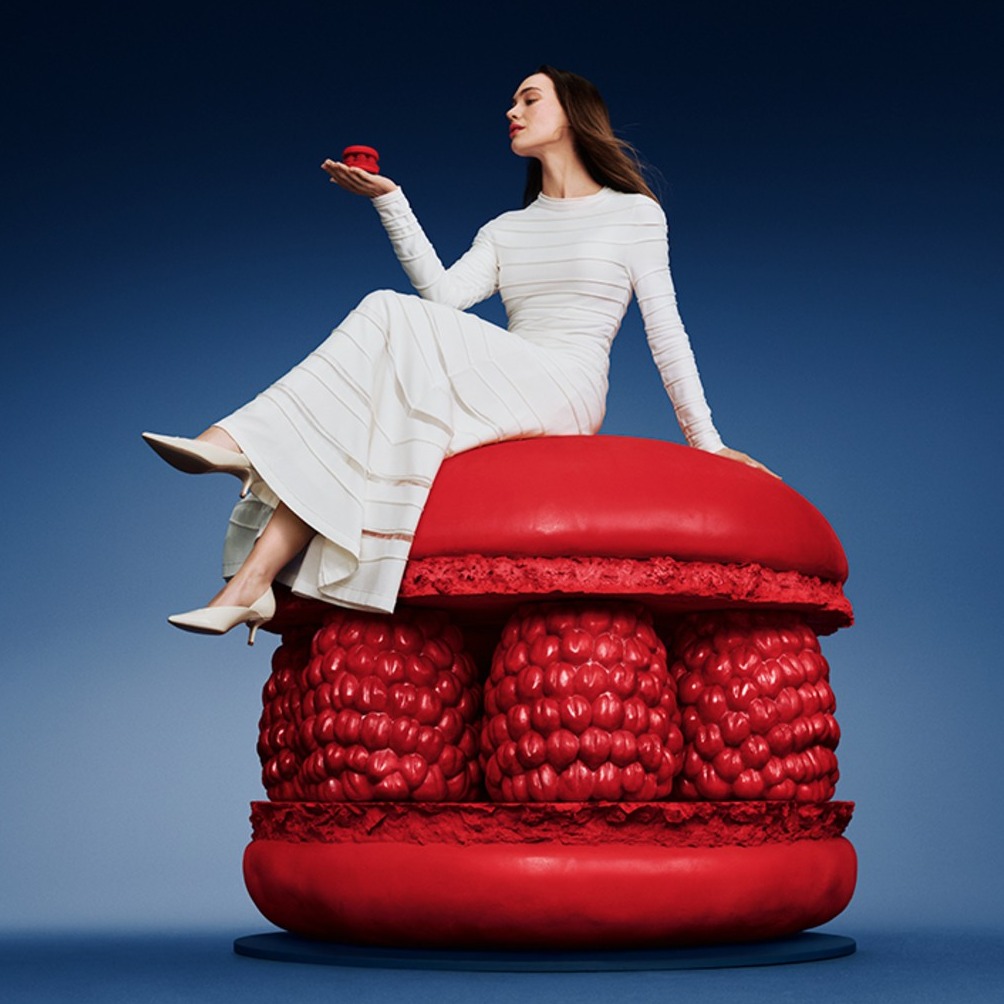 Mujer sentada en un macaron gigante