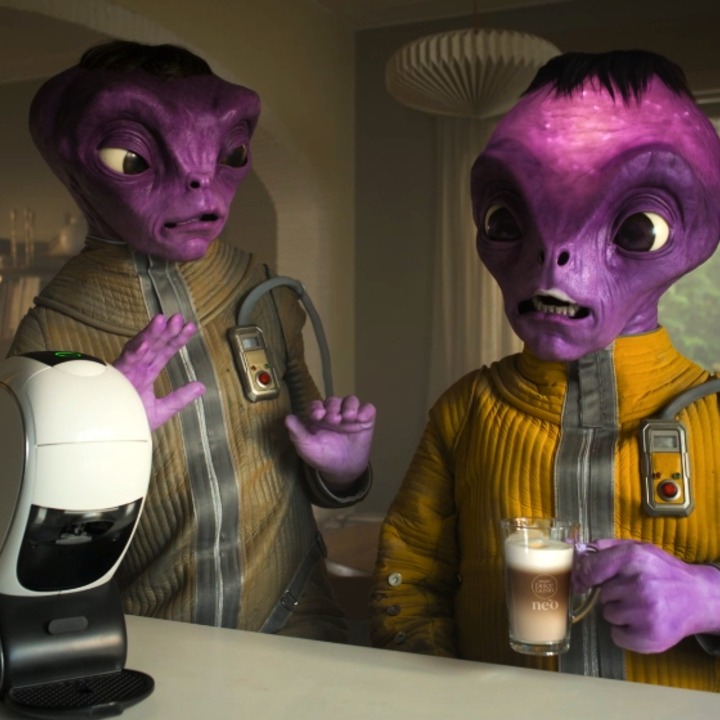 Dos marcianos morados preparándose un Nescafé en una máquina