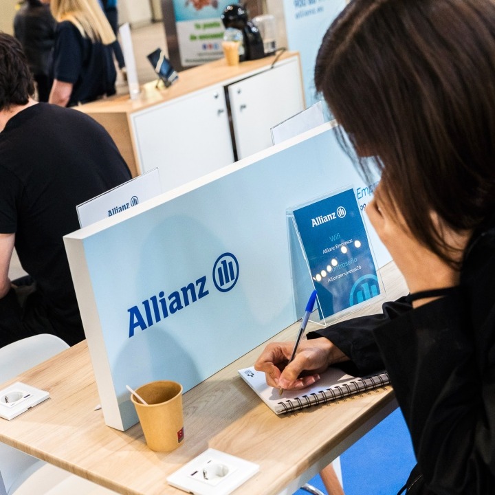 Personas trabajando en la cabina de Allianz dentro de la estación de tren