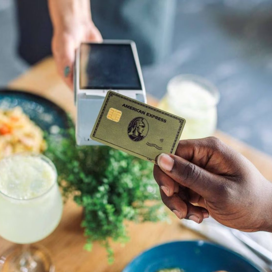 Persona pagando en un datáfono con una tarjeta de American Express
