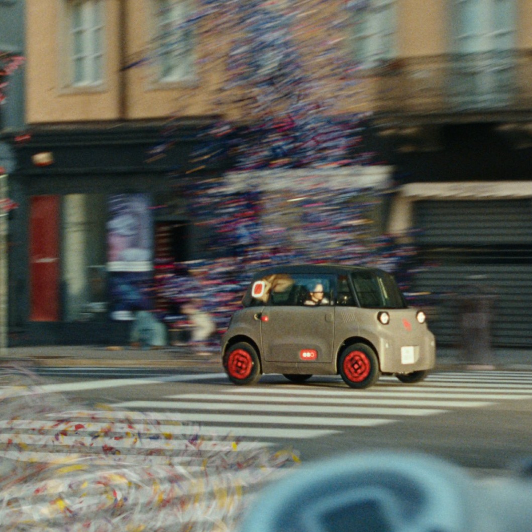 Un Citroën Ami por la ciudad circulando entre confeti