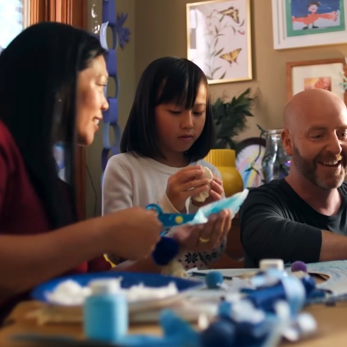 La familia del anuncio haciendo manualidades navideñas en colores azules