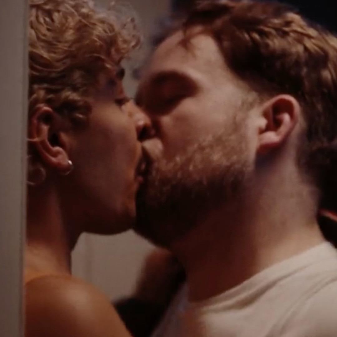 Dos hombres jóvenes besándose