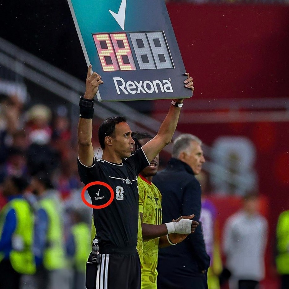 Dos árbitros sosteniendo el marcador y dejando ver el logo de Rexona en la axila de la camiseta
