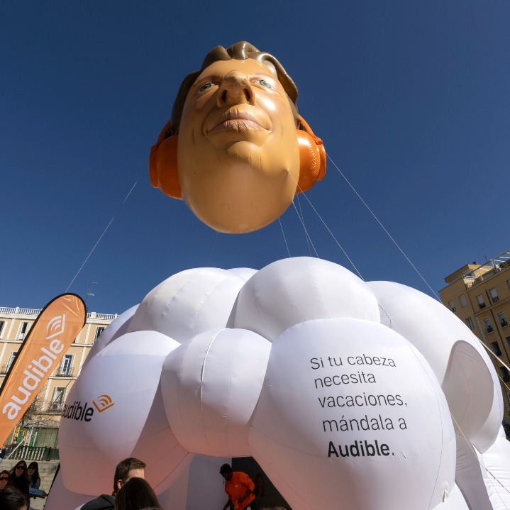 La instalación de Audible en forma de nube con una cabeza gigante flotando encima como un globo aerostático