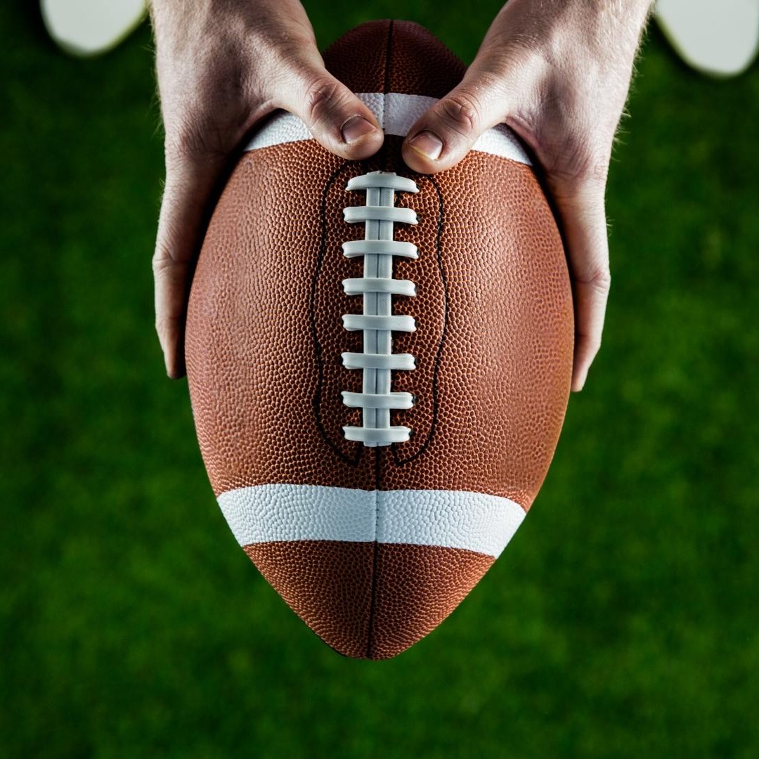 Manos sujetando un balón de rugby