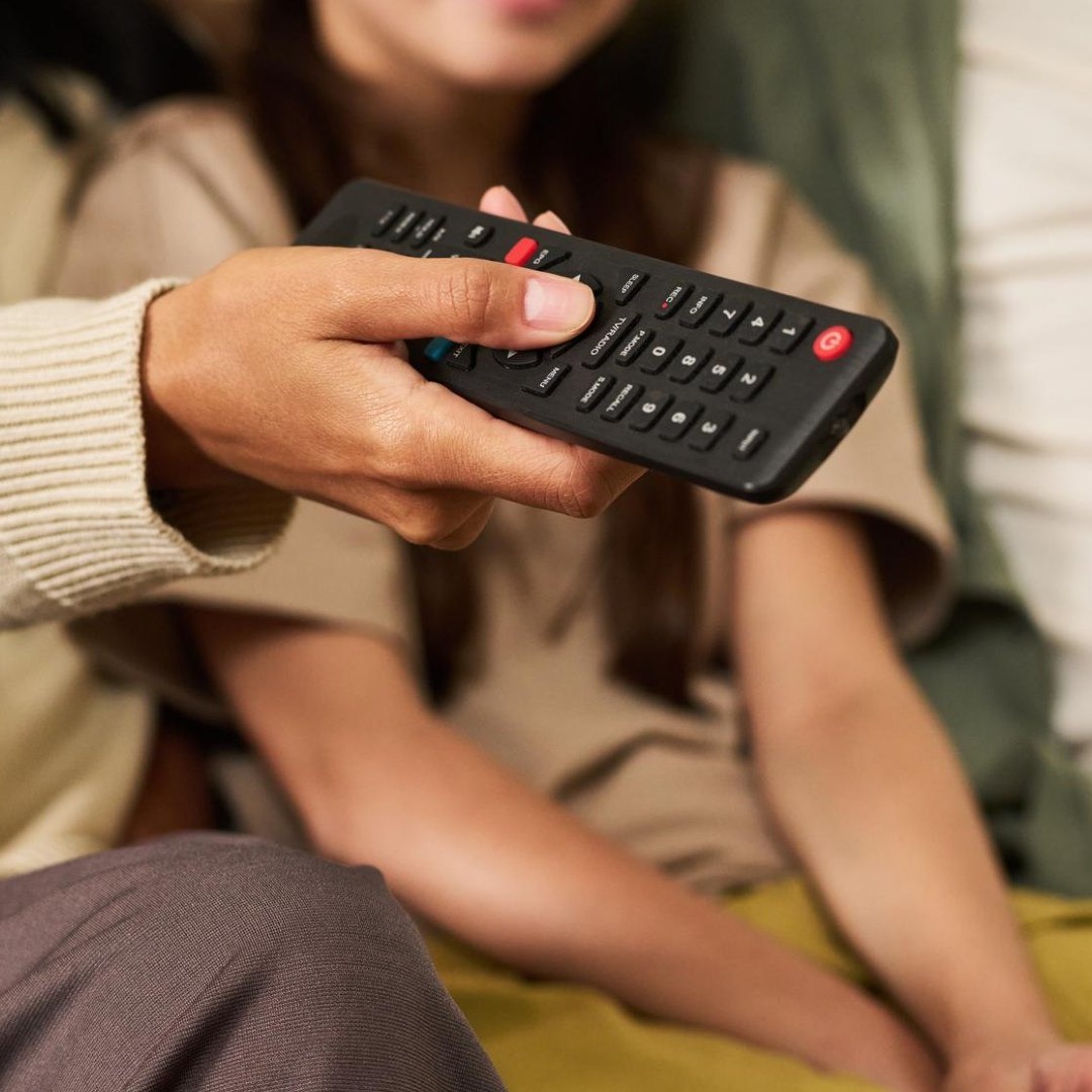 Mujer sujeta un mando de televisión