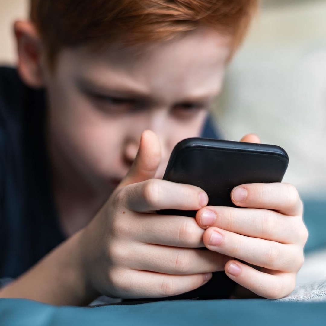 Niño mirando un teléfono móvil