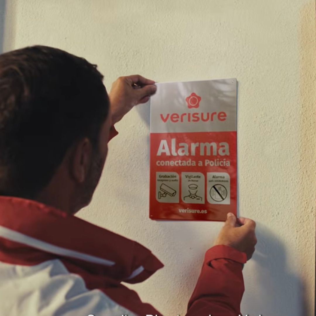 Hombre colgando un cartel de Verisure