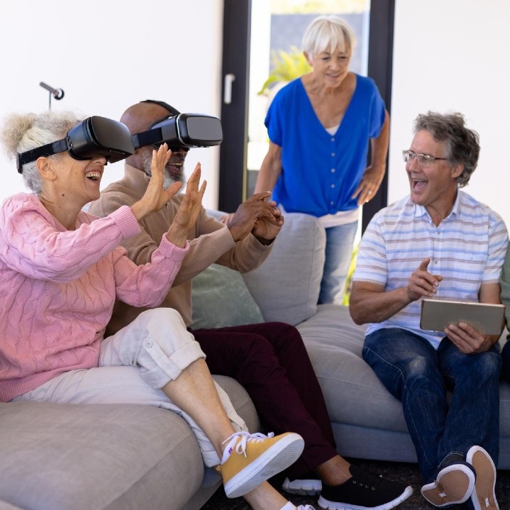 Un grupo de baby boomers probando unas gafas inteligentes en el salón