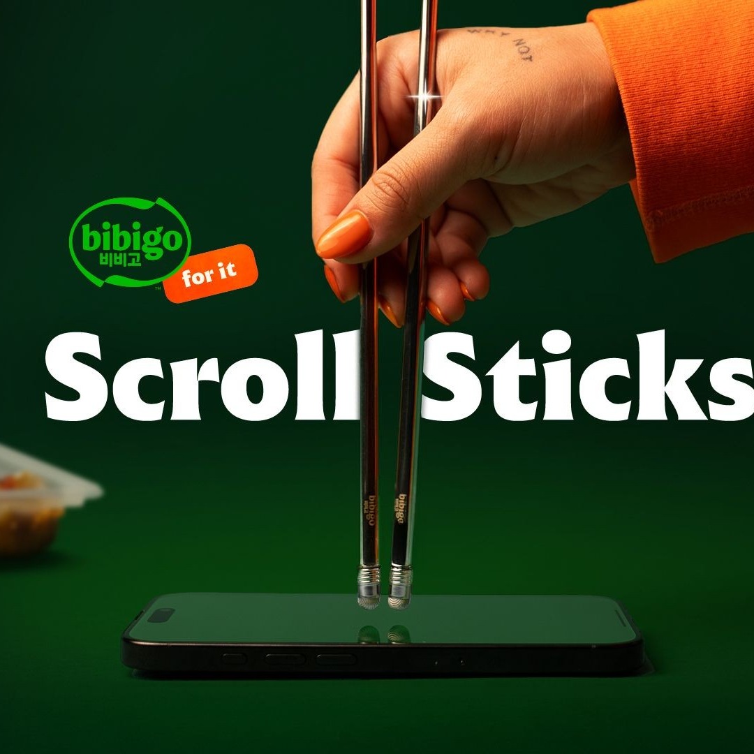 Mano de persona deslizando unos palillos chinos sobre la pantalla de un movil