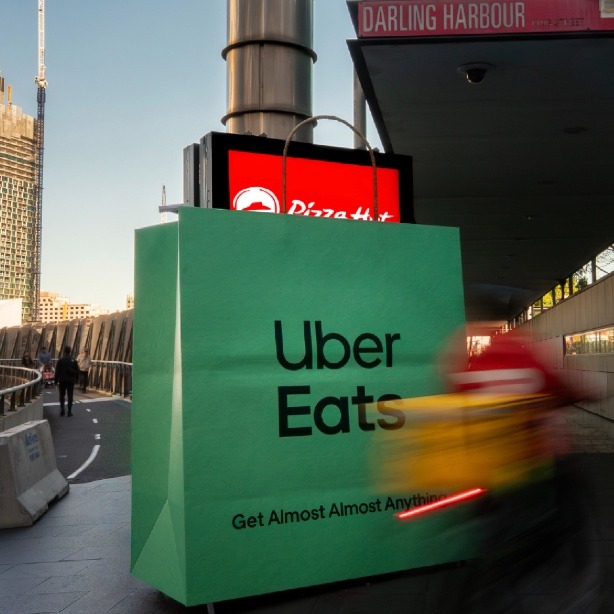 Mupis en la calle envueltos por la bolsa de Uber Eats que deja entrever los logos de Pizza Hut y Burger King