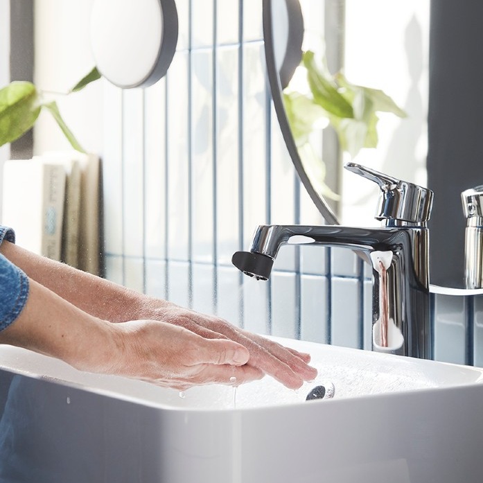 persona lavándose las manos en un lavabo