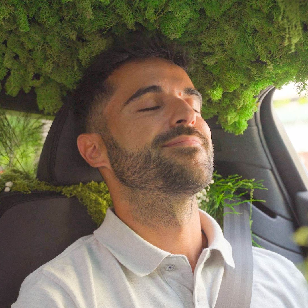 Chico dentro de un coche adornado como un bosque