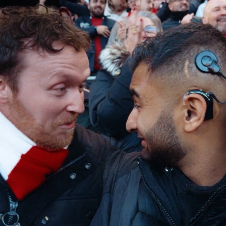 Dos aficionados se miran en el estadio, uno de ellos lleva un audífono