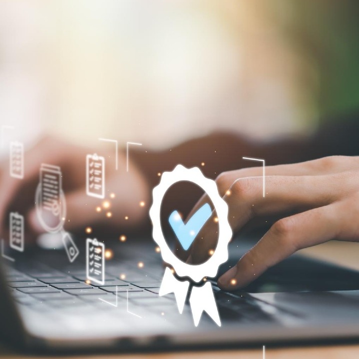 Una manos sobre un teclado y un sello de certificación sobreimpreso