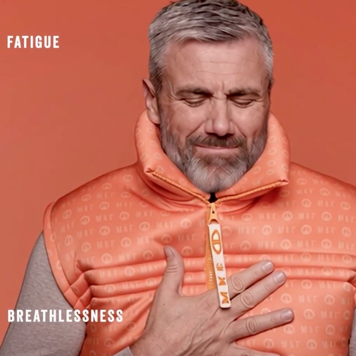 Un hombre con el chaleco de la colección llevándose la mano al pecho con rostro de incomodidad