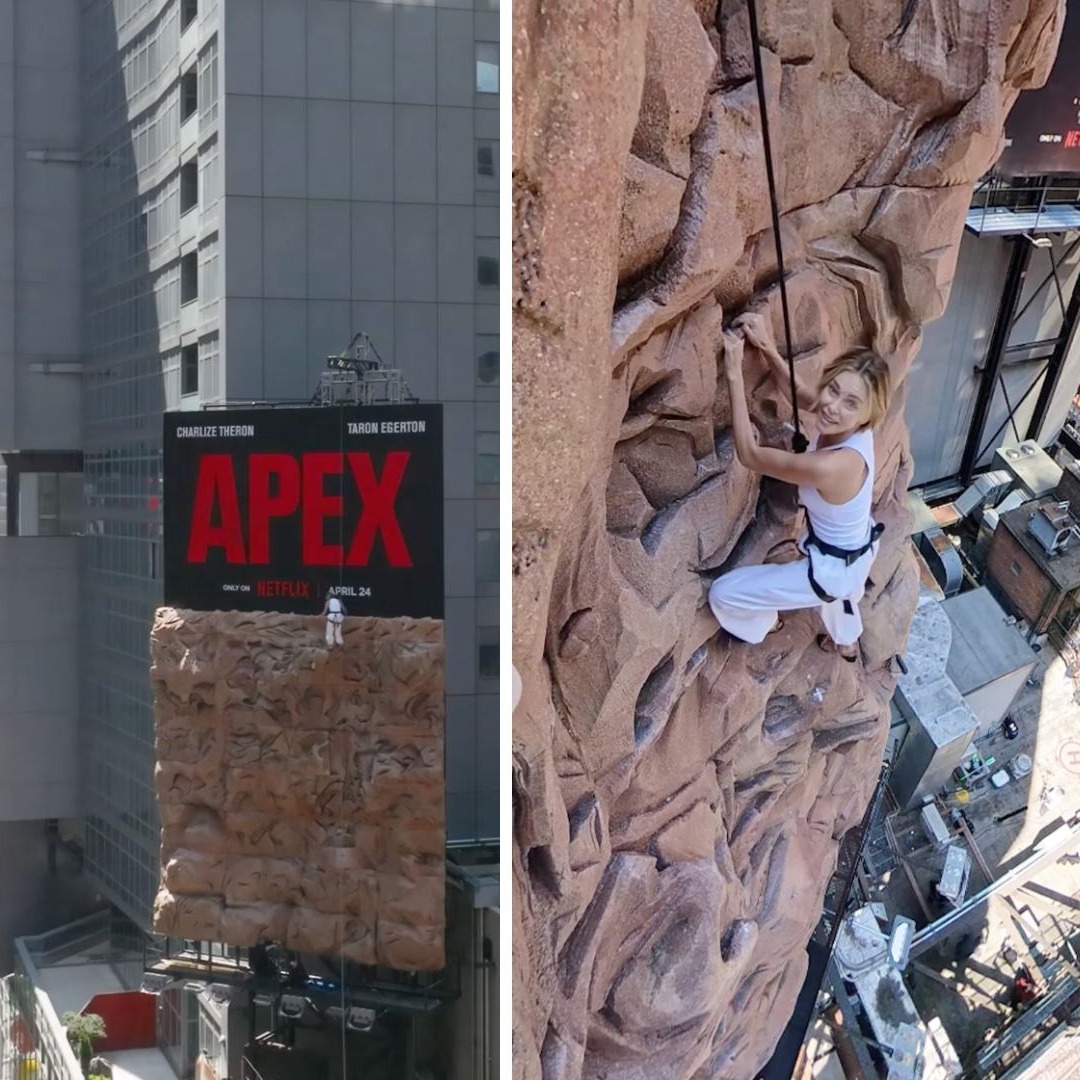 Charlize Theron escalando una valla publicitaria