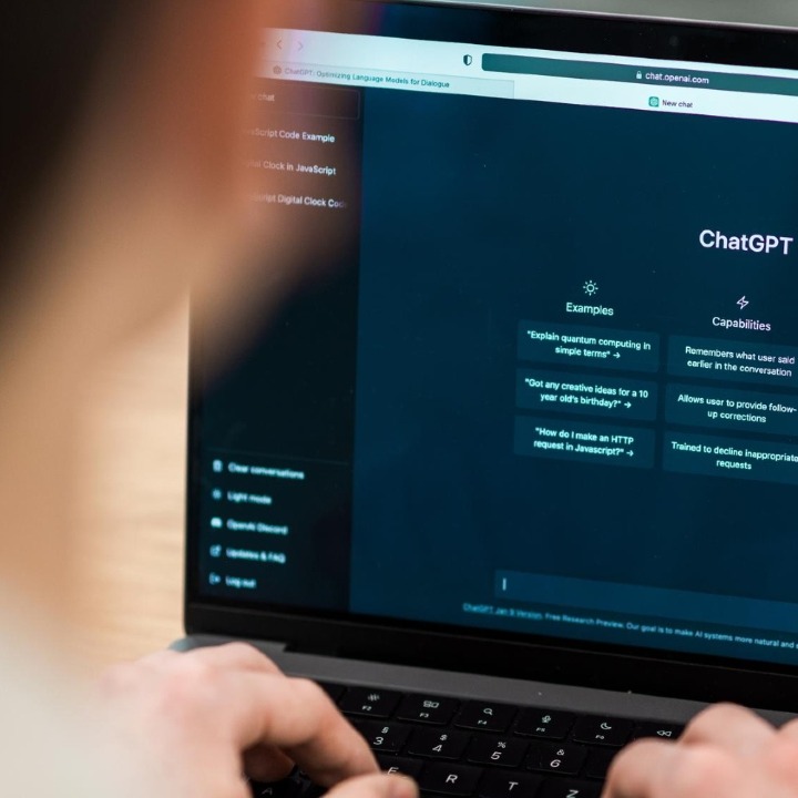 Un hombre usando el ordenador con ChatGPT en la pantalla