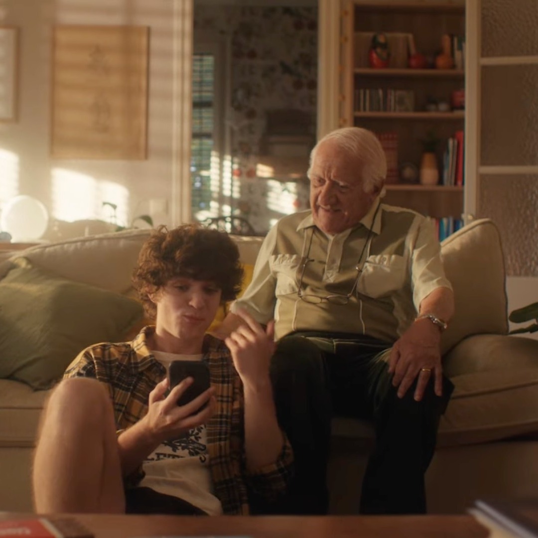 Un abuelo y un nieto sentados en el sofá hablando