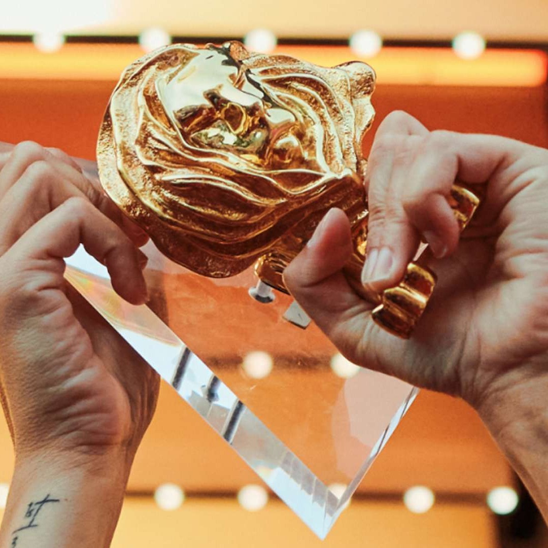 Manos sujetando trofeo de Cannes Lions