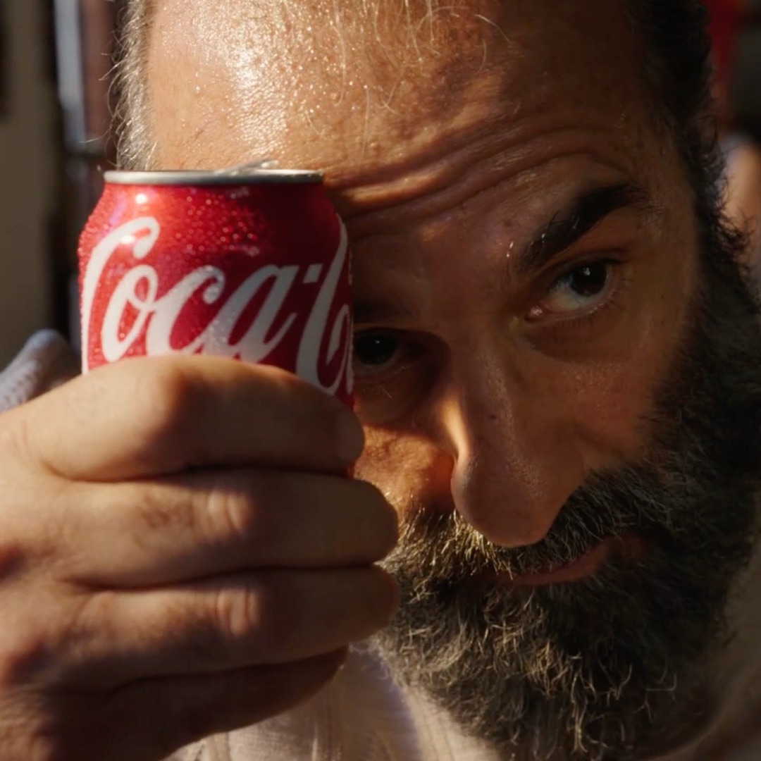 Un hombre refresca su frente con una lata de Coca-Cola