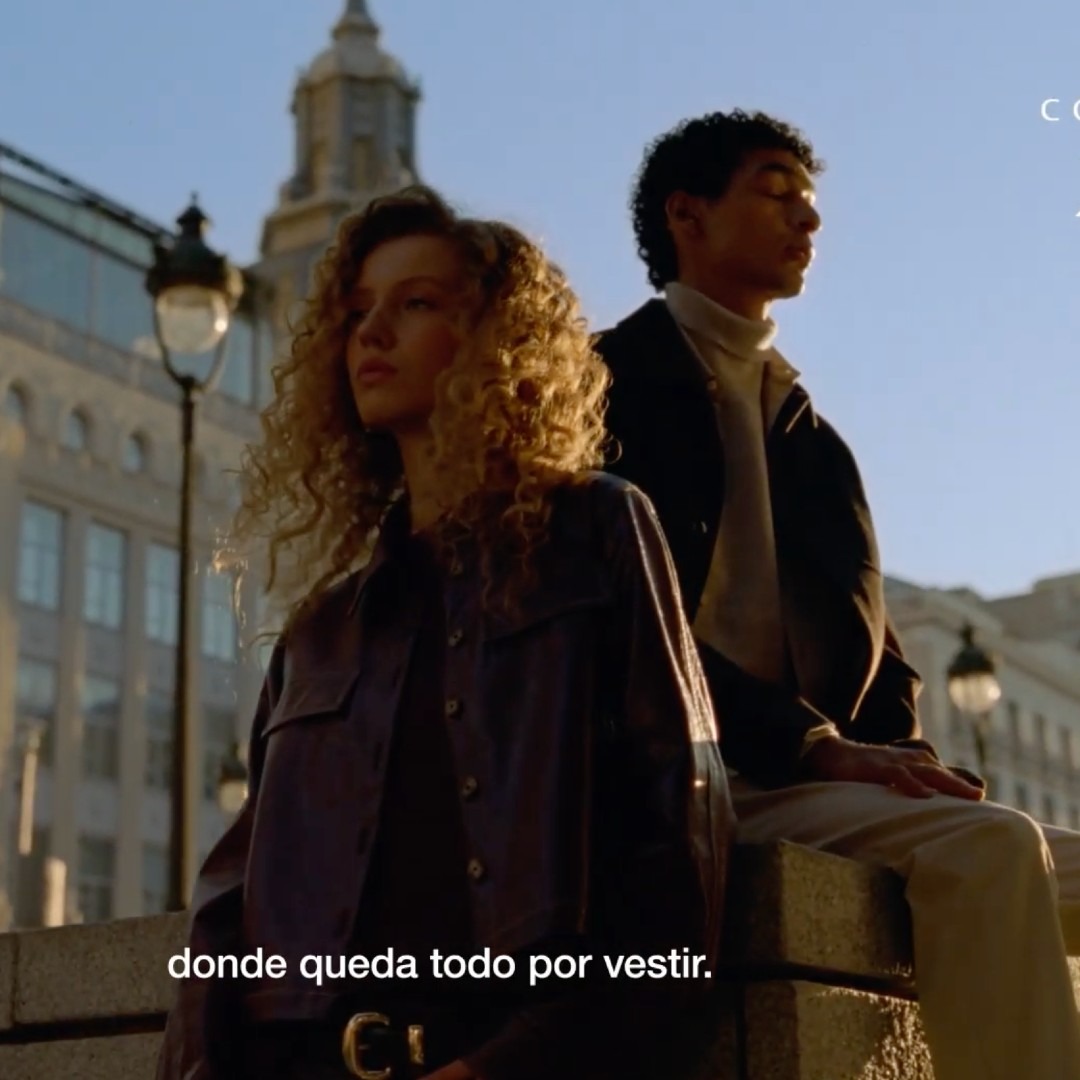 Dos jovenes ante edificios de la Gran Vía de Madrid en un annuncio de Cortefiel