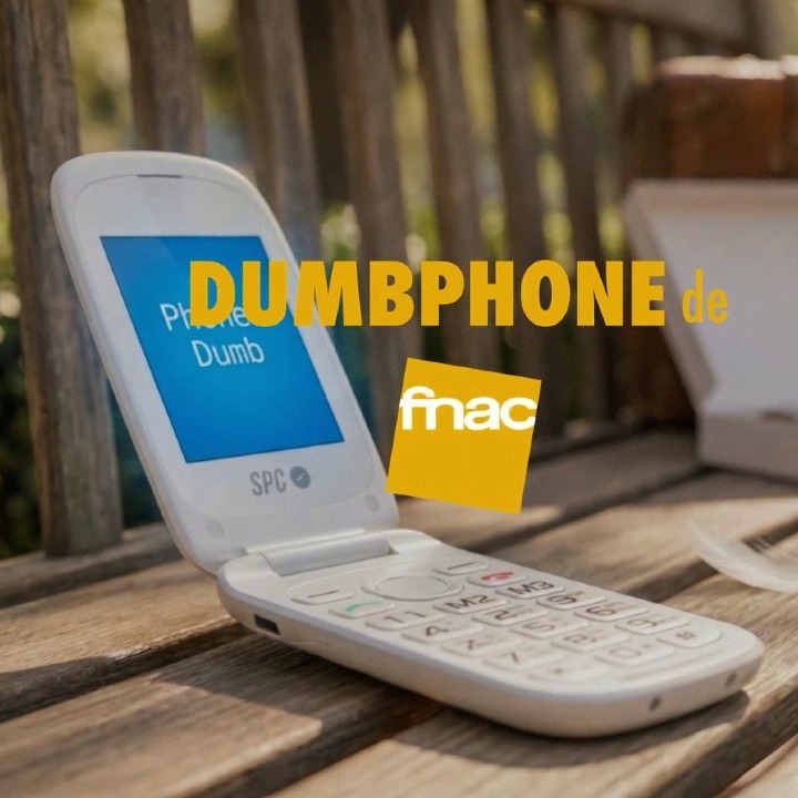 El dumbphone de Fnac abierto sobre un banco de madera en la calle