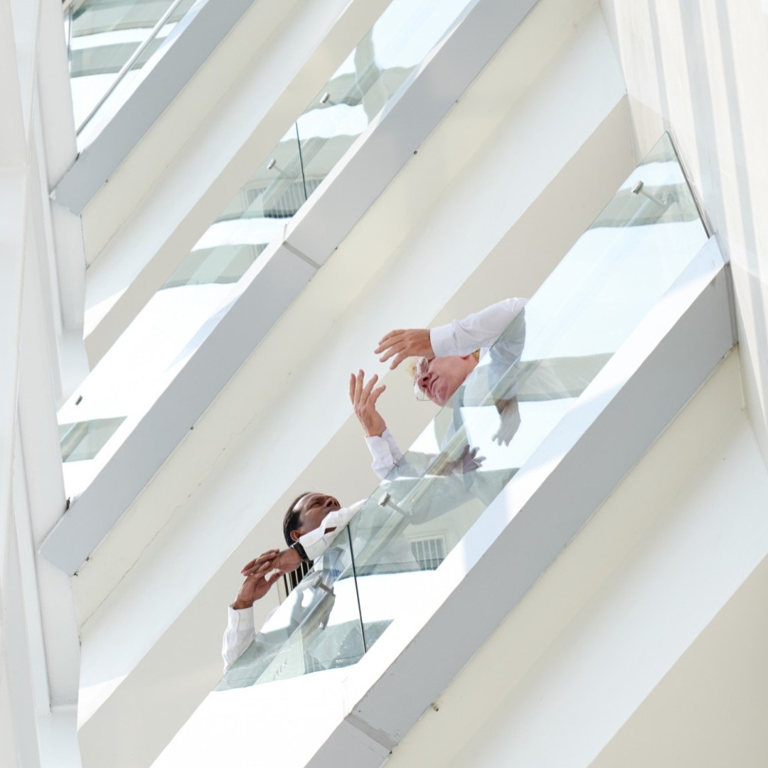 Dos hombres hablan en las escaleras de una oficina