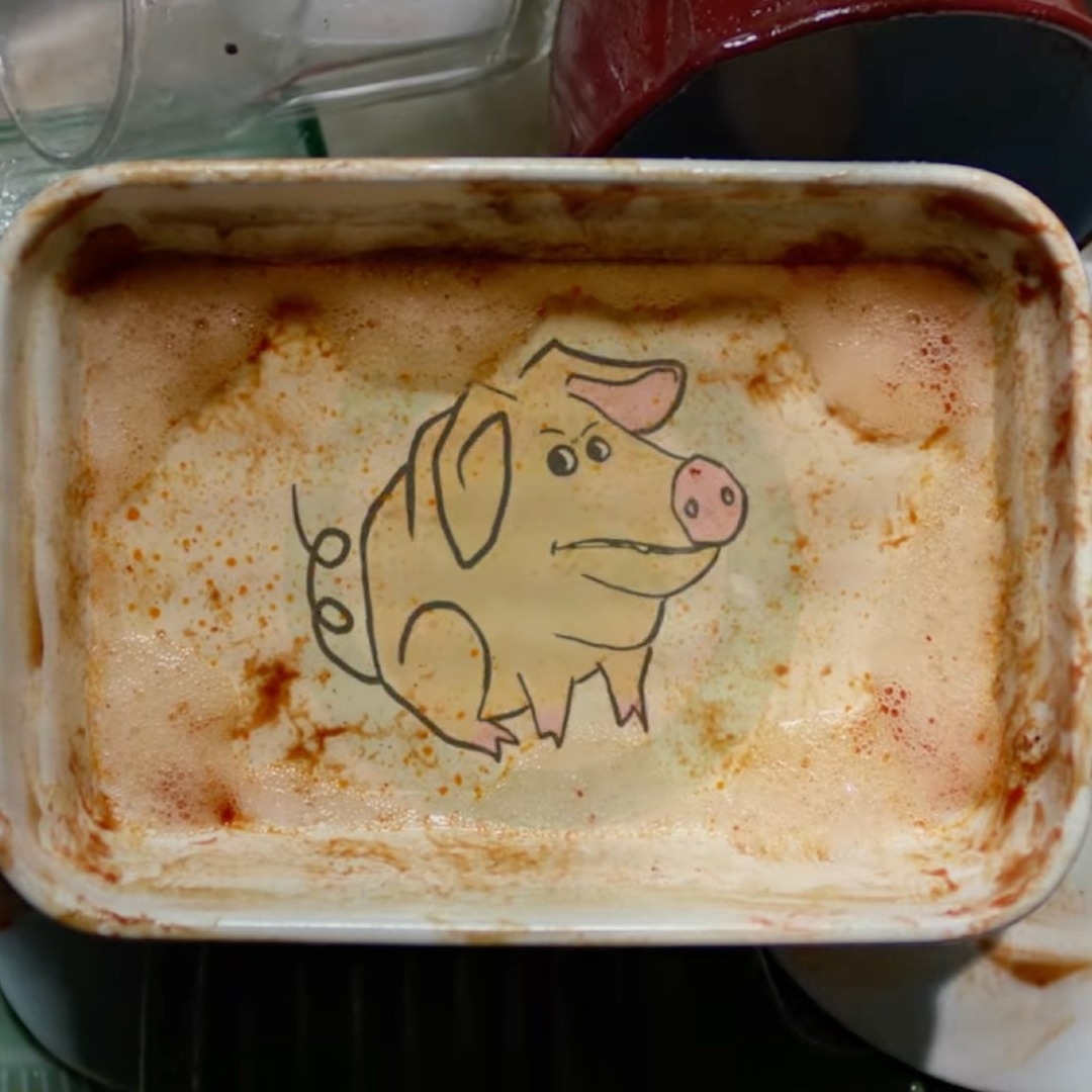 Fuente de cocina con un grabado de un cerdo a remojo en el fregadero