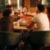 Un grupo de personas brindan en una mesa de restaurante