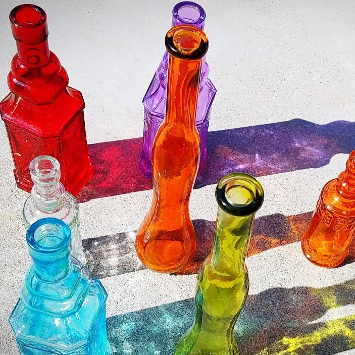 botellas de cristal de colores generando sombras