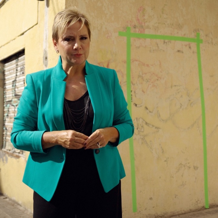 Gloria Serra frente a una pared con una puerta pintada