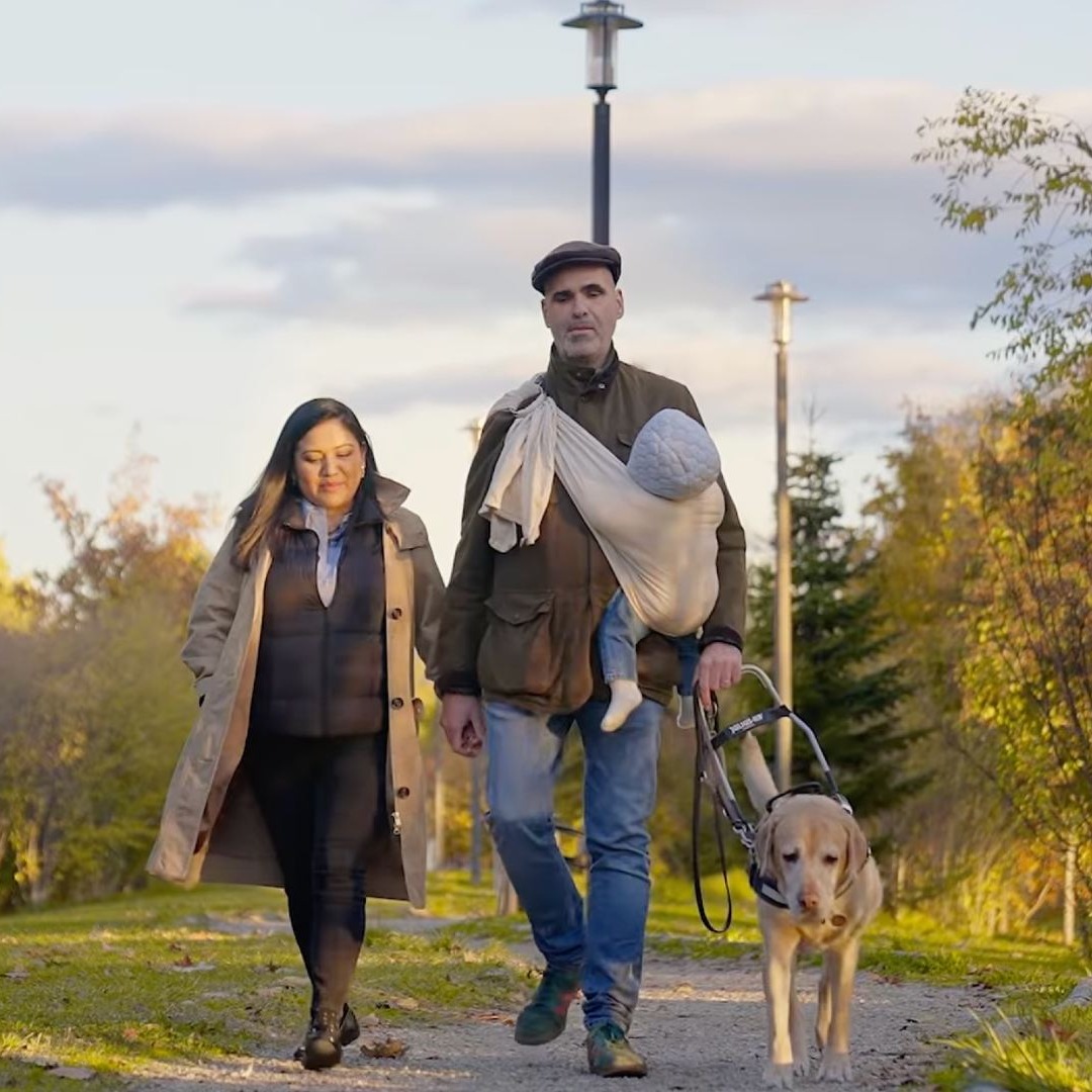 Un hombre ciego paseando con su perro y su familia