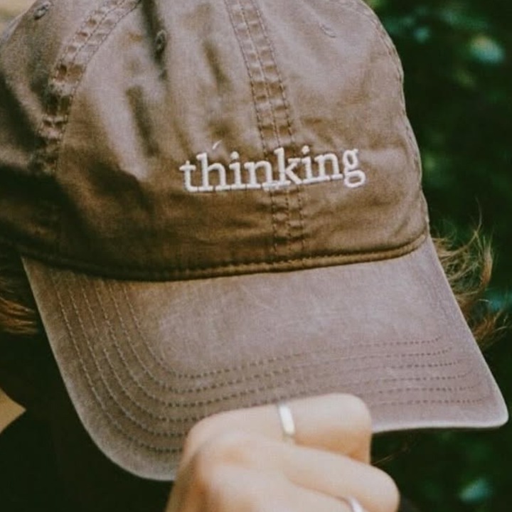 Anthropic convierte un quiosco en un espacio para pensar y reivindica el papel humano en la era de la inteligencia artificial un hombre sosteniendo una gorra marrón en la cabeza donde se puede leer "thinking"