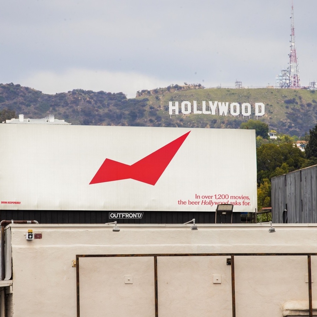 valla publicitaria de Budweiser en lo alto de un edificio, con la señal de Hollywood en Los Ángeles de fondo