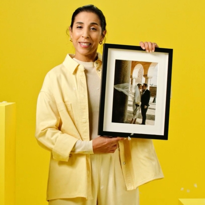 Una mujer enseña un cuadro con la foto de su boda