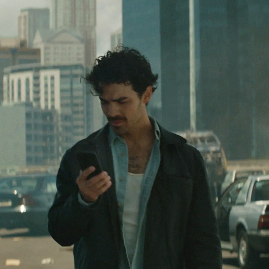 Heineken y Joe Jonas animan a separarse de las pantallas desde un mundo ficticio sin redes sociales Joe Jonas mirando un teléfono móvil en una ciudad arrasada y sin habitantes
