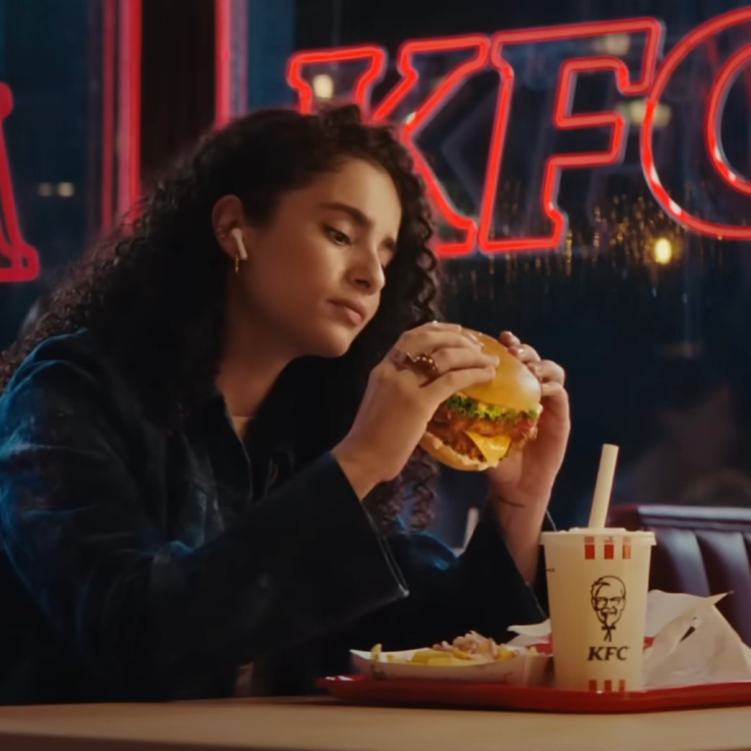 Chica comiendo una hamburguesa en un restaurante KFC