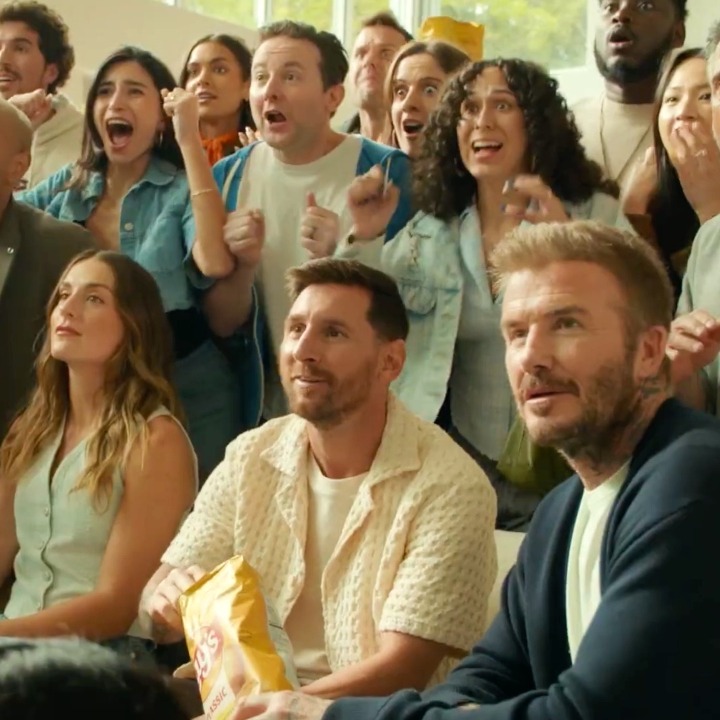 Alexia Putellas, Leo Messi y David Beckham en un salón rodeados de gente viendo el fútbol