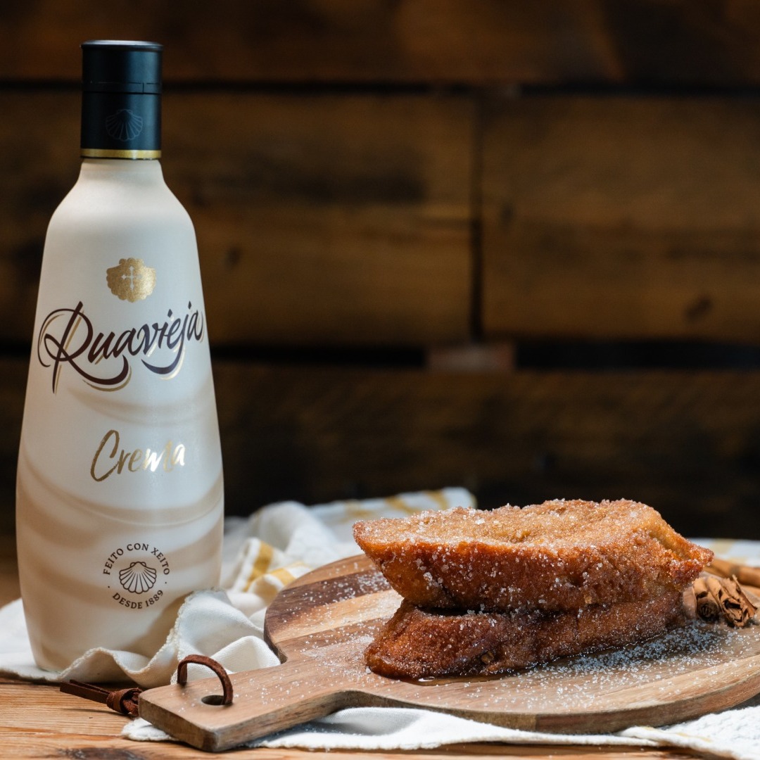 nueva torrija de Levaduramadre con crema Ruavieja, sobre una tabla y junto a una botella de la bebida