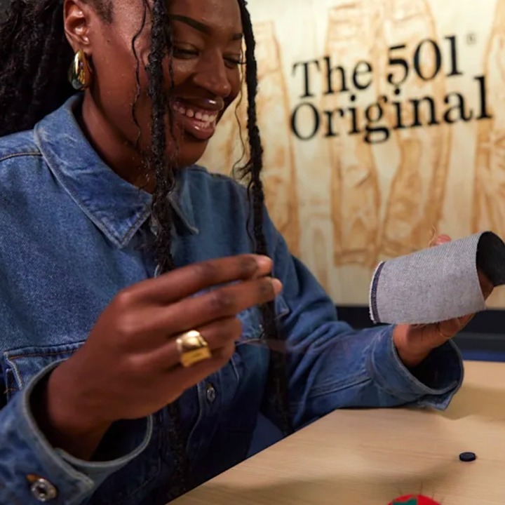 Dos chicas con aguja e hilos riendo mientras intentan coser