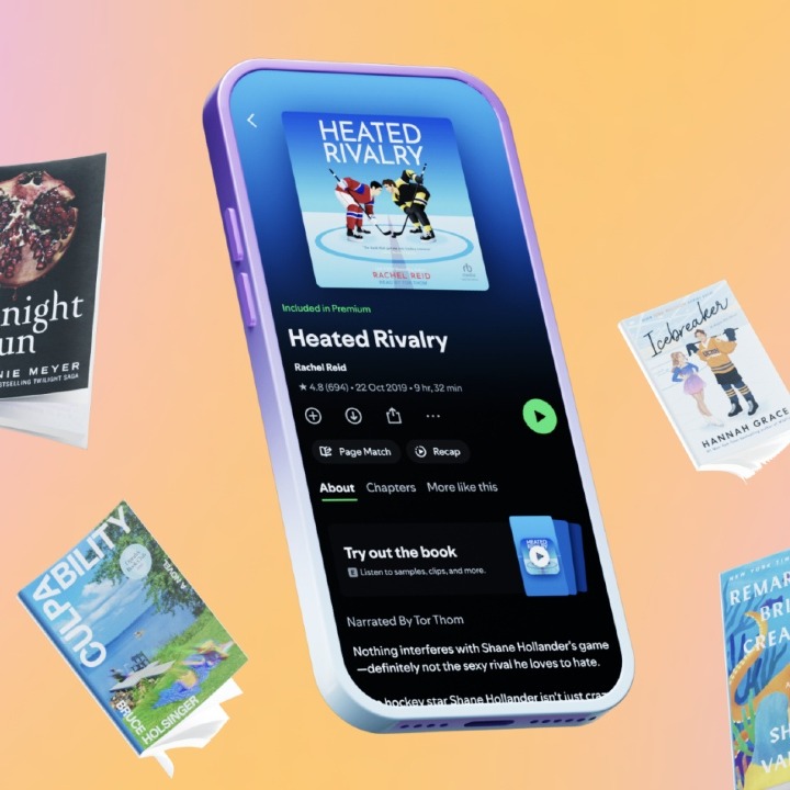 Un móvil mostrando la interfaz de un audiolibro en Spotify, rodeado de  libros físicos flotando alrededor