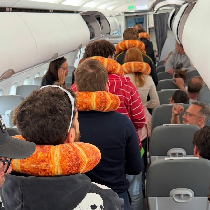 Personas en el avión con la almohada de croissant en el cuello