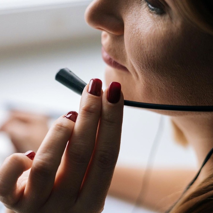 Una operadora cogiendo el micrófono de los auriculares para llamadas