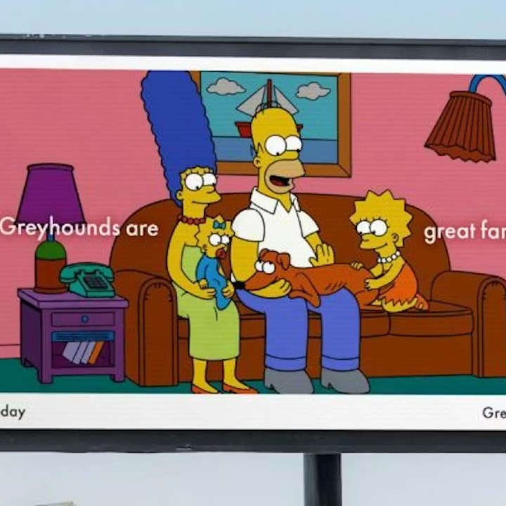 Los Simpson sentados en el sofá abrazando a su galgo